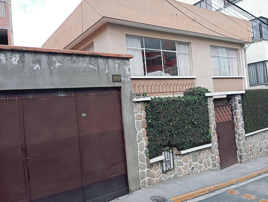 a house with two garage doors and ivy at Bello departamento independiente in La Paz