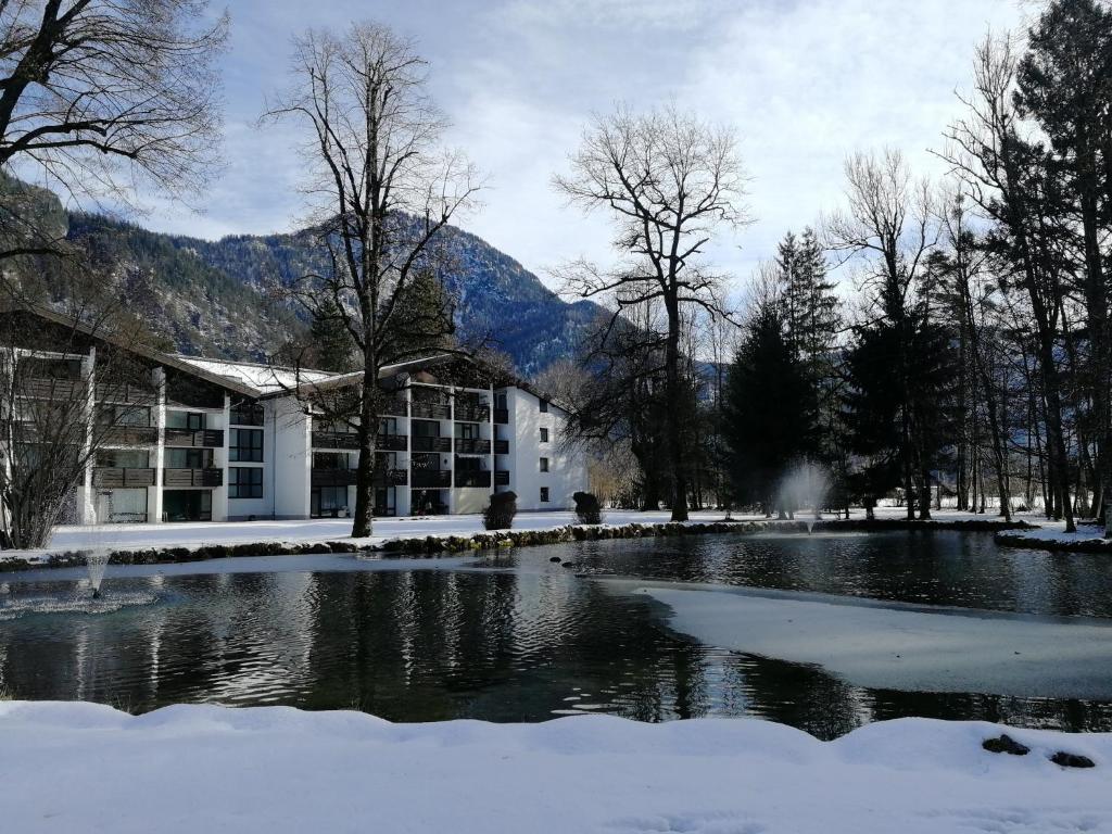 a building with a pond in the snow at Schloss Grubhof Appartement in Sankt Martin bei Lofer