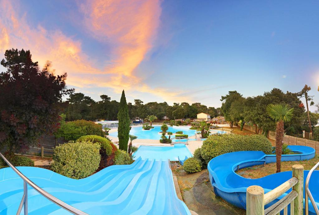 - une grande piscine avec des toboggans bleus dans un complexe dans l'établissement Camping Saint-Palais-Sur-Mer, à Saint-Palais-sur-Mer