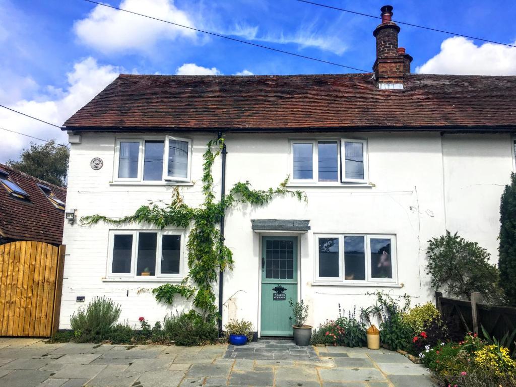 una casa bianca con una porta verde di Lavender Row Stedham a Midhurst