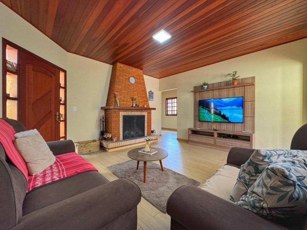 a living room with two couches and a fireplace at Casa Luar in Monte Verde