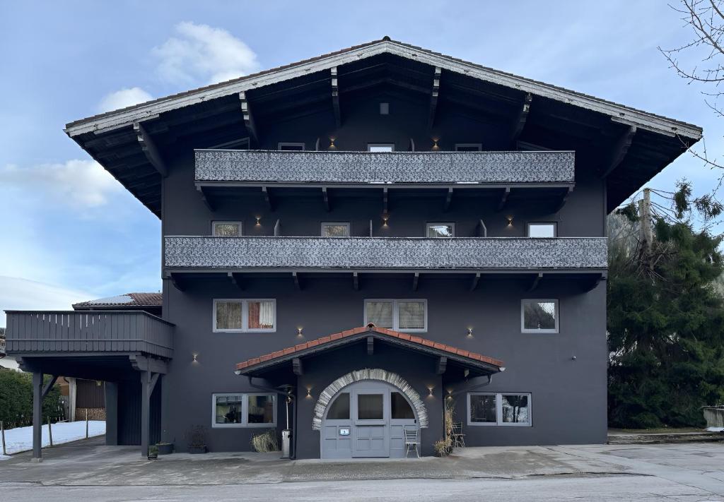 a large black building with a garage at Two Brothers Inn in Pertisau
