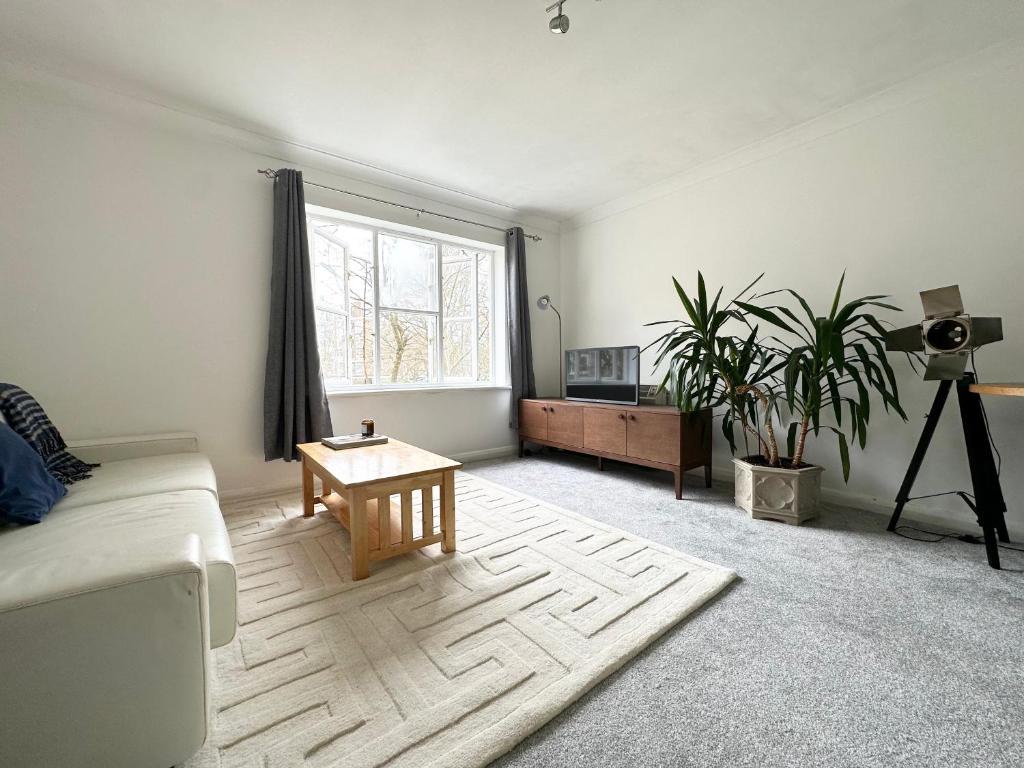 a living room with a couch and a table at Spacious Quiet Stylish entire flat in London