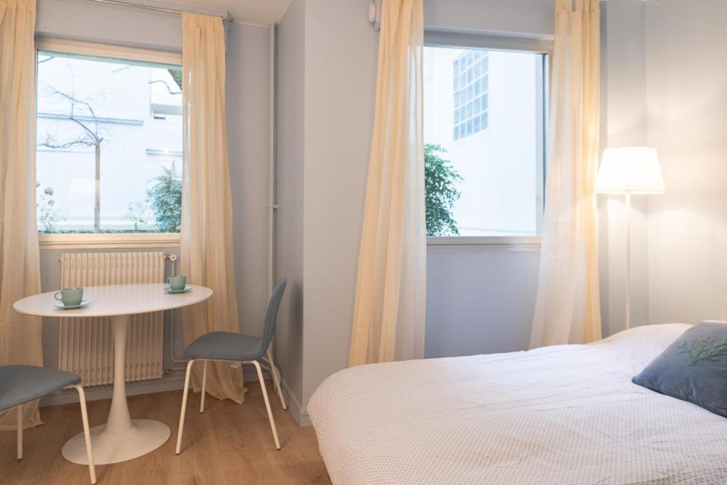 1 dormitorio con 1 cama, mesa y sillas en Quiet radiant studio overlooking the garden, en París