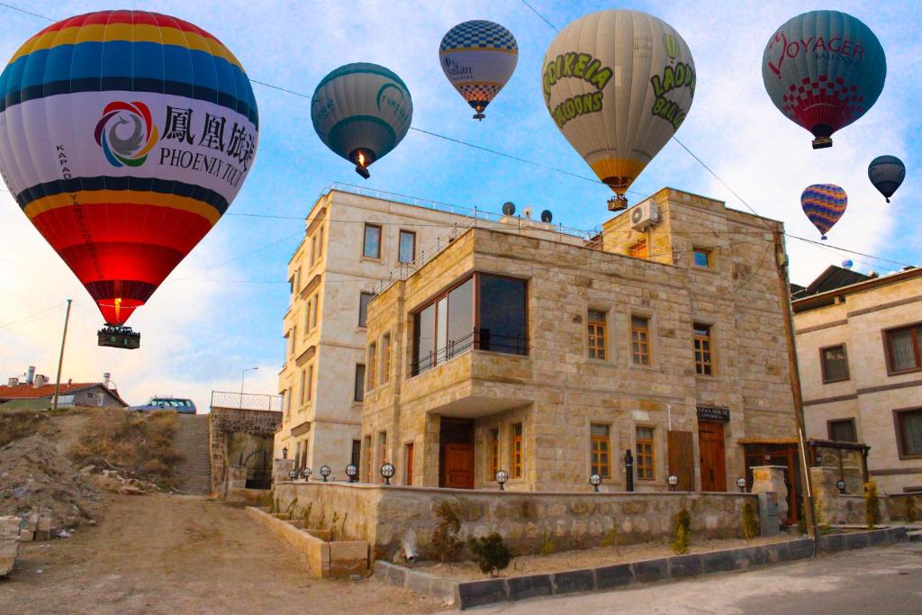 a group of hot air balloons flying over a building at Tantan Cappadocia House in Avcılar