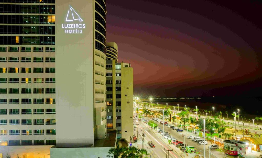 een gebouw met een bord naast een straat bij Hotel Luzeiros Fortaleza in Fortaleza