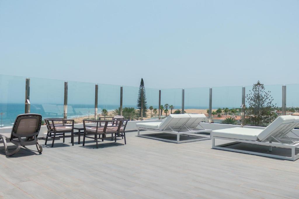 a group of lounge chairs and tables on a roof at Apartamentos El Palmar in Playa del Ingles