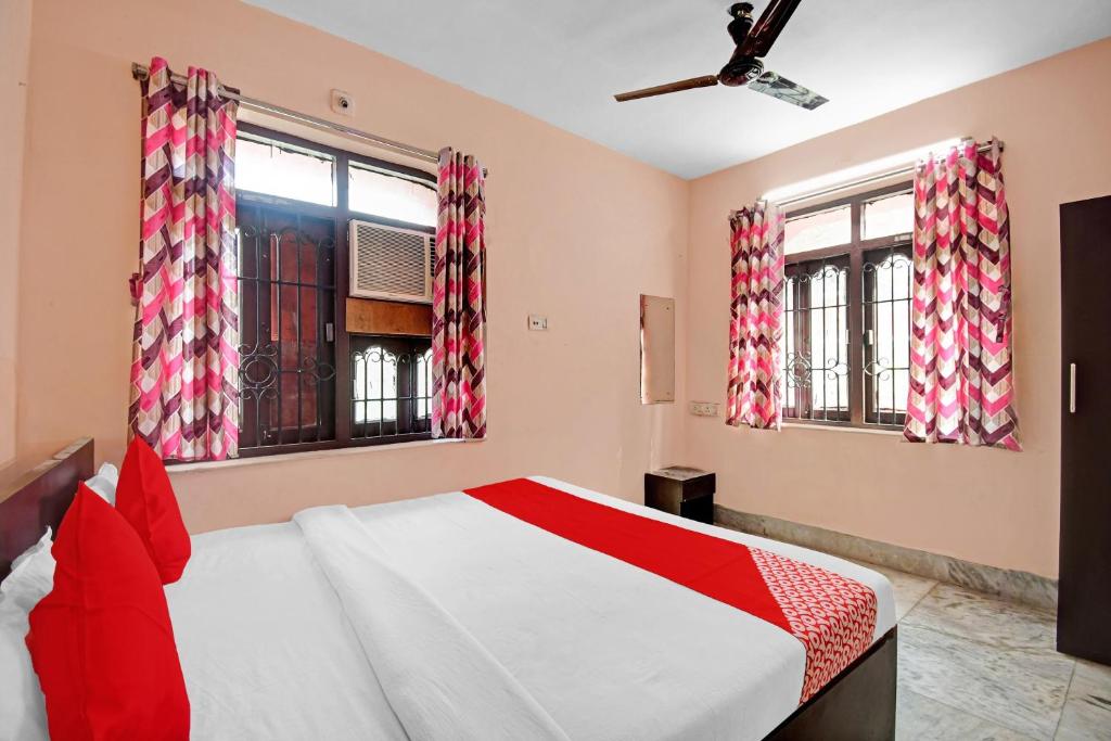 a bedroom with a bed and two windows at OYO Flagship 87255 Seema Stays Inn in Thākurdwari