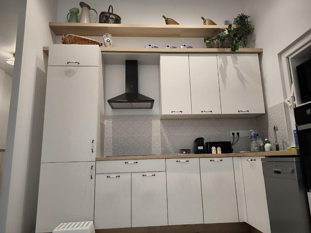- une cuisine avec des placards blancs et une cuisinière dans l'établissement Maison en Baie Du Mont, à Roz-sur-Couesnon