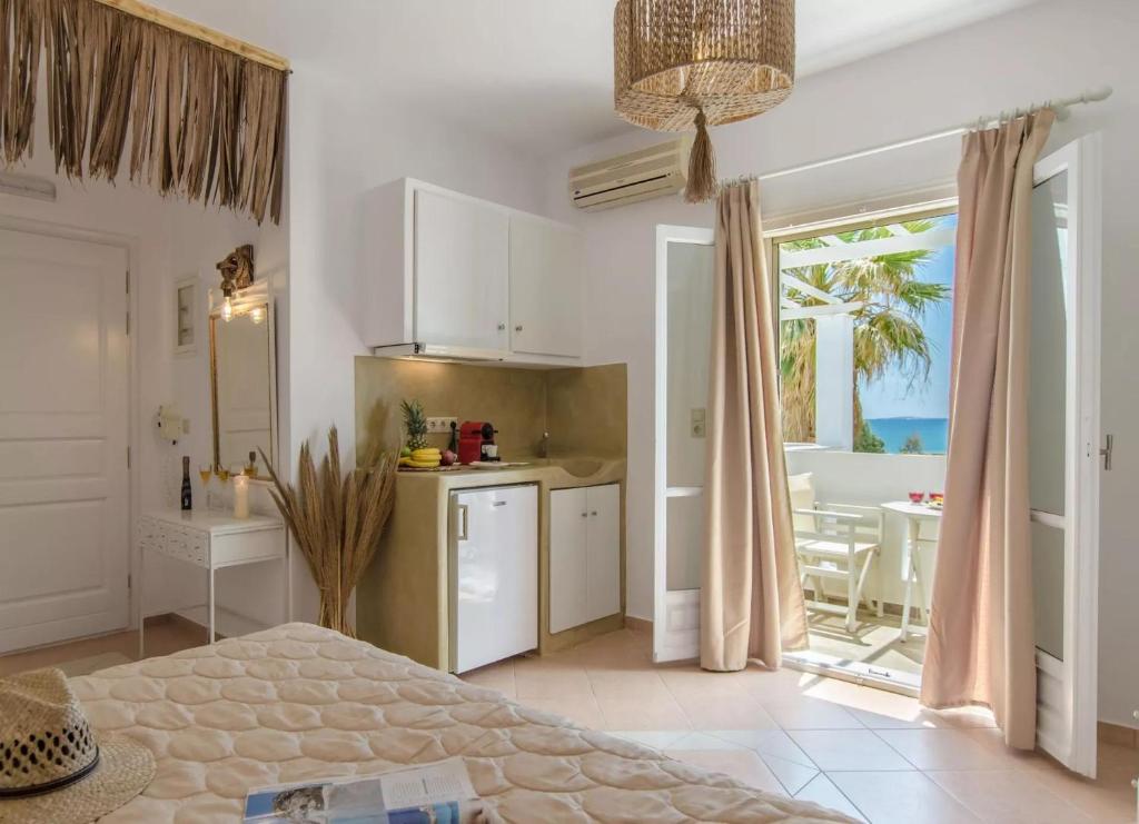 a bedroom with a kitchen and a dining room with a table at Glaronissi Beach in Plaka