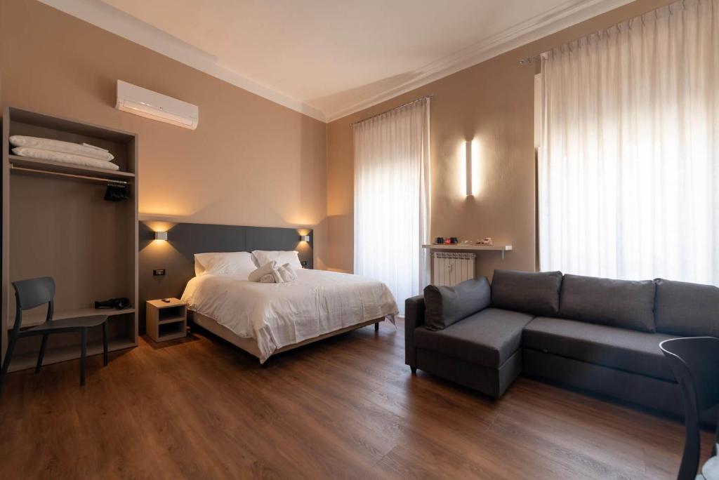 una camera d'albergo con letto e divano di Torino Station Relais a Torino