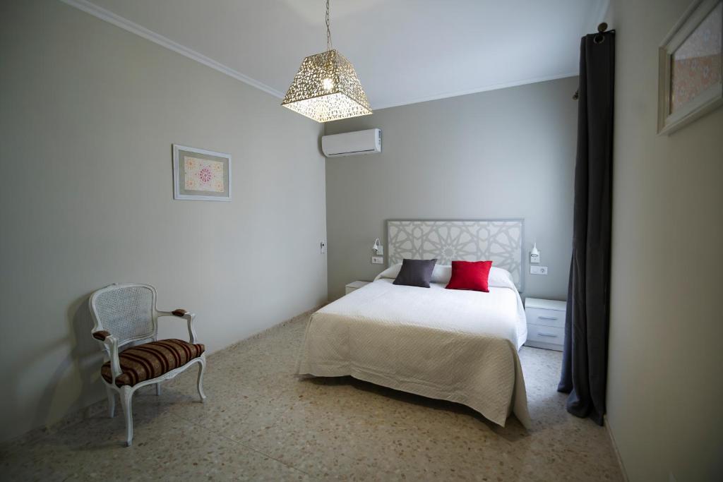 a bedroom with a bed with red pillows and a chair at Altalune Apart in Córdoba