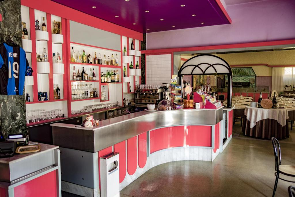 un restaurante con un bar con armarios rojos y blancos en Albergo Sporting, en Endine Gaiano