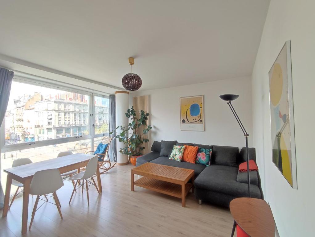 een woonkamer met een bank en een tafel bij Au cœur de Strasbourg, 3 pièces vue sur l'Ill! in Straatsburg