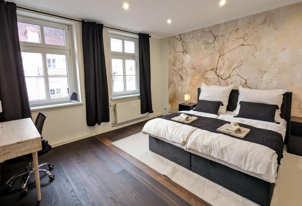 a bedroom with a large bed and two windows at Altstadt-oase in Cottbus