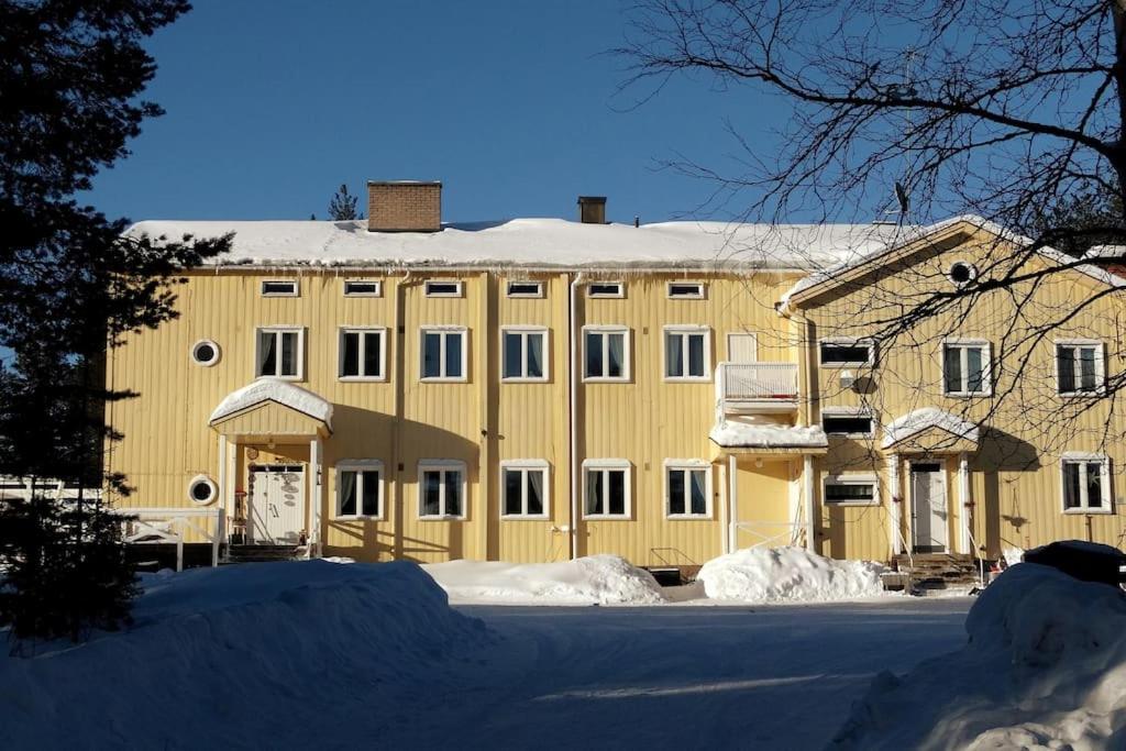 ケミヤルヴィにあるthe old school of halosenrantaの雪の大きな黄色の建物
