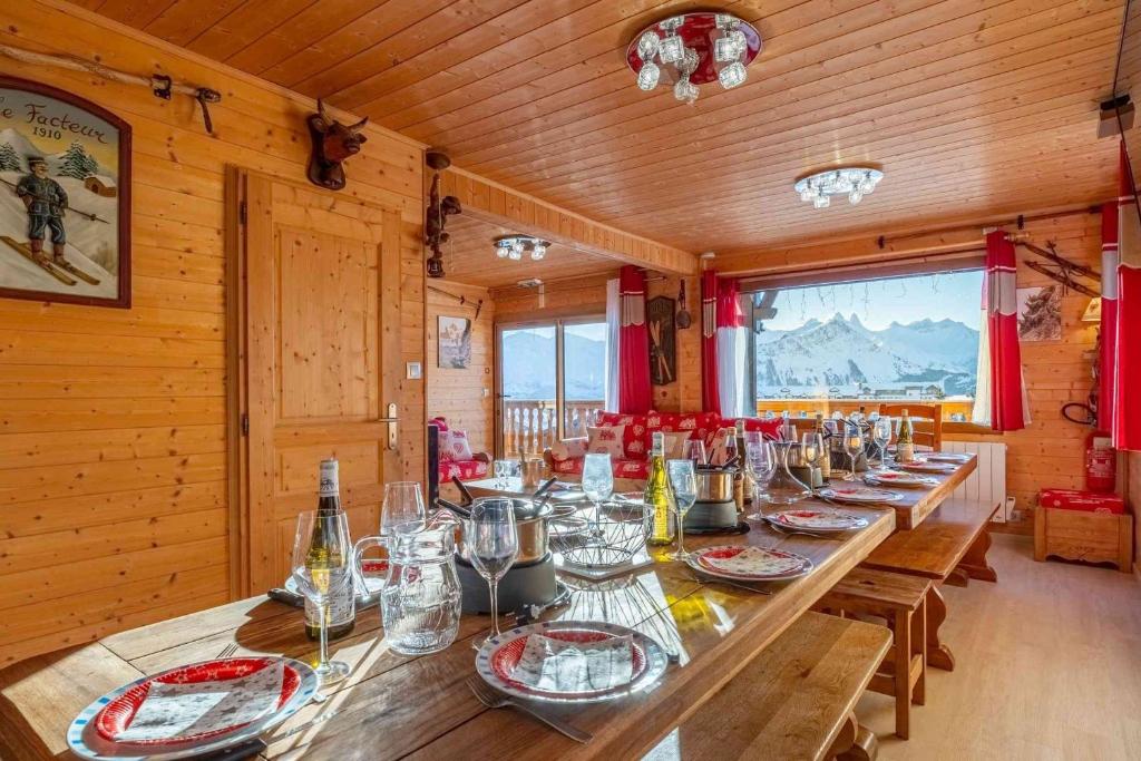 - une longue table en bois dans une pièce avec des verres dans l'établissement Duplex - Chalet - 15 personnes, à La Toussuire