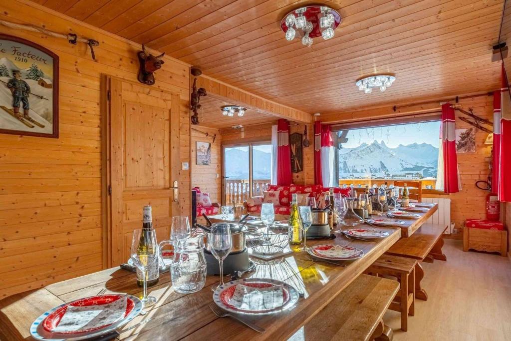 a long wooden table in a room with glasses on it at Duplex - Chalet - 15 personnes in La Toussuire