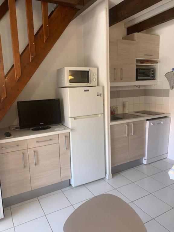La cuisine est équipée d'un réfrigérateur blanc et d'un four micro-ondes. dans l'établissement Ideal for your seaside vacation, à Frontignan