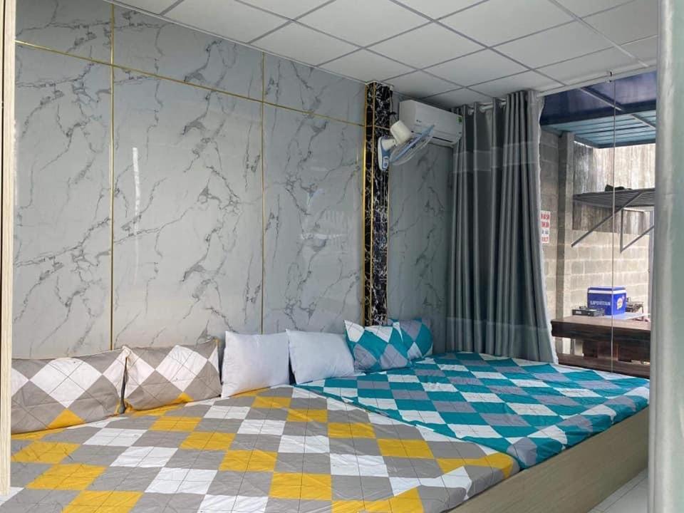 a bedroom with a bed with a checkered floor at Phúc Nguyễn House in Lagi