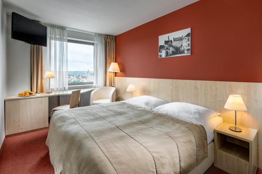 a hotel room with a large bed and a window at Clarion Congress Hotel České Budějovice in České Budějovice