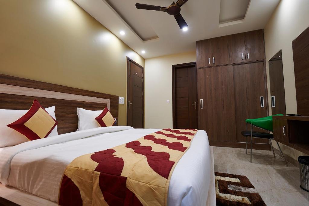 a bedroom with a large bed and a dresser and a desk at The Indian Hotel Near Medanta Hospital in Gurgaon