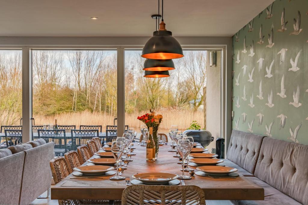 a dining room with a long table and chairs at Goslings in Somerford Keynes