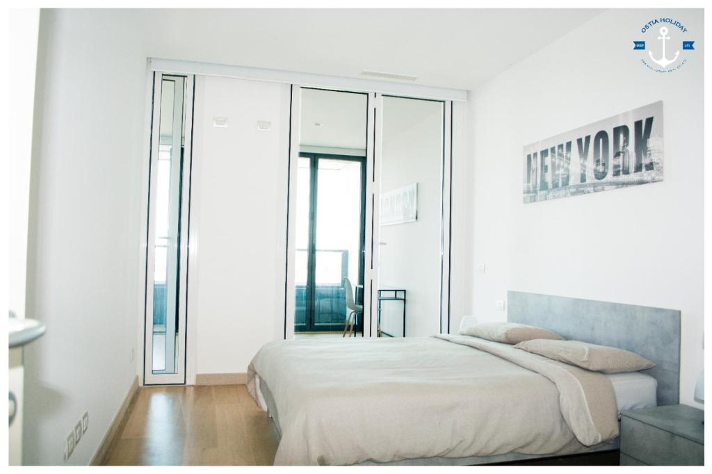 a white bedroom with a bed and a mirror at Eurosky Twelve in Rome