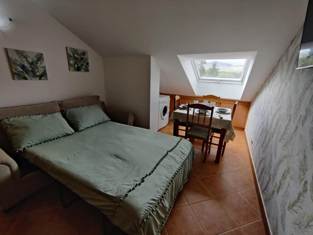 - une petite chambre avec un lit et une table dans l'établissement Apartamento Río Gallo, à Cuntis