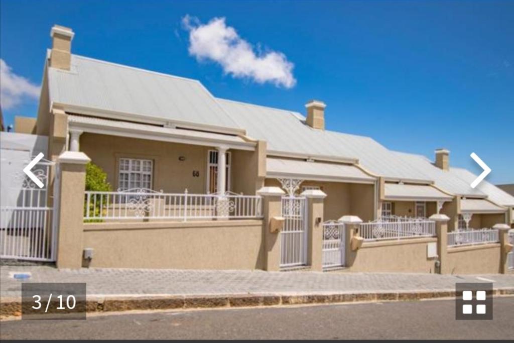 een groot huis met een dak op een straat bij Duke & Dutchess in Kaapstad