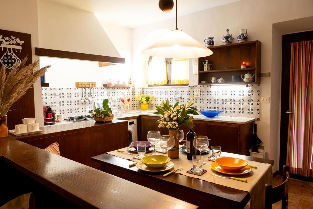 una cocina con una mesa de madera con gafas. en Casa con Giardino Pieno Centro Storico a Due Passi dal Duomo, en Orvieto