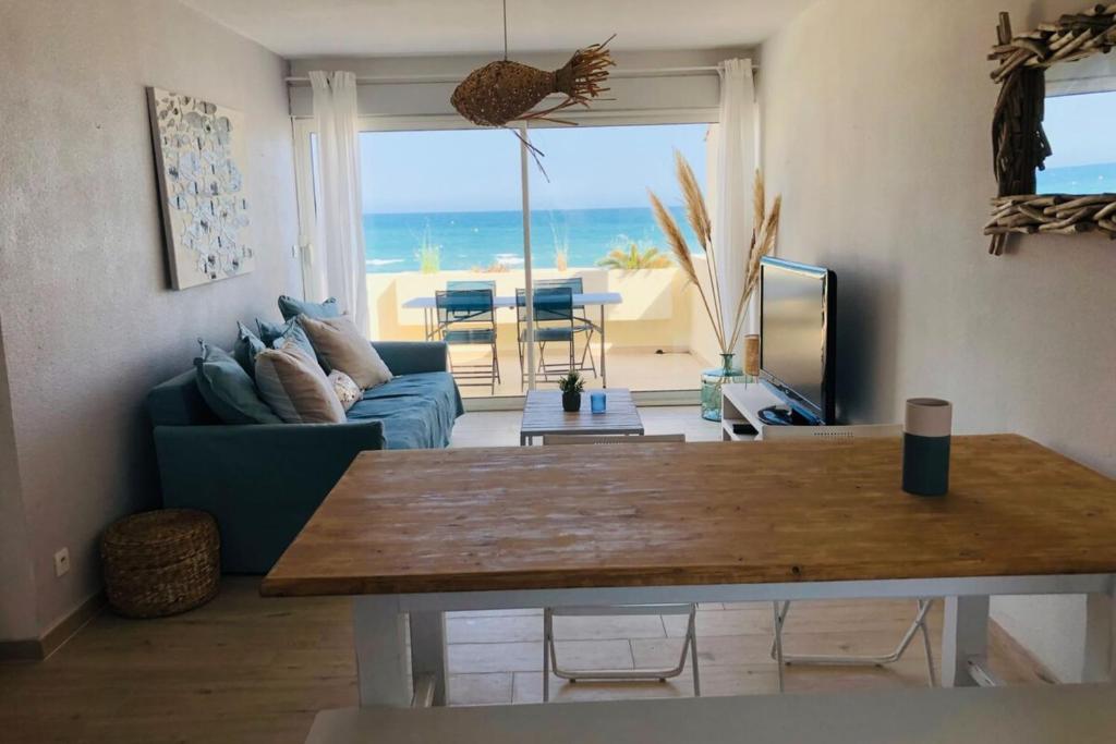 un salon avec un canapé bleu et une table dans l'établissement Seaside spirit, à Frontignan