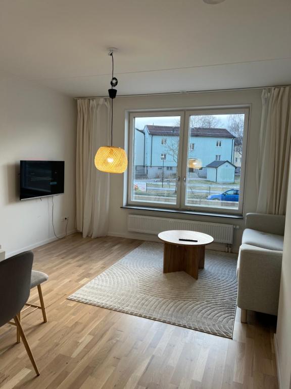 a living room with a couch and a table at Cozy apartment 2 stops-15 mins away from city center in Stockholm