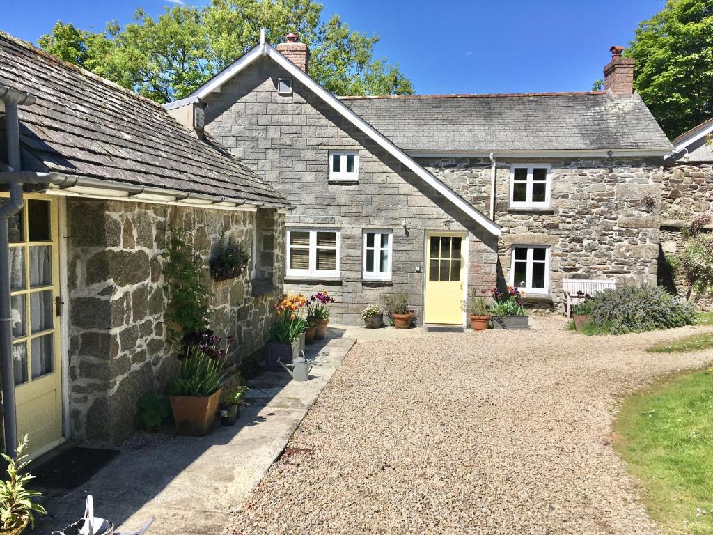 an old stone house with a yellow door at Little Pengelly Farm in Crowan