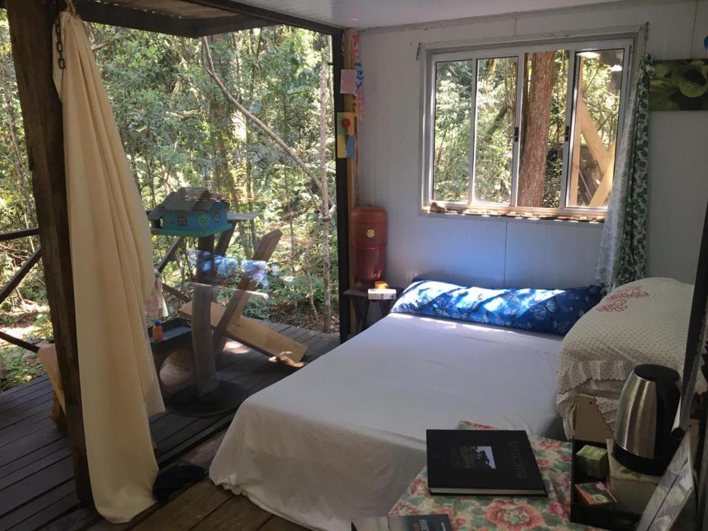 a bedroom with a bed and a window at Bosque Contêiner Eco Guaricana in São José dos Pinhais