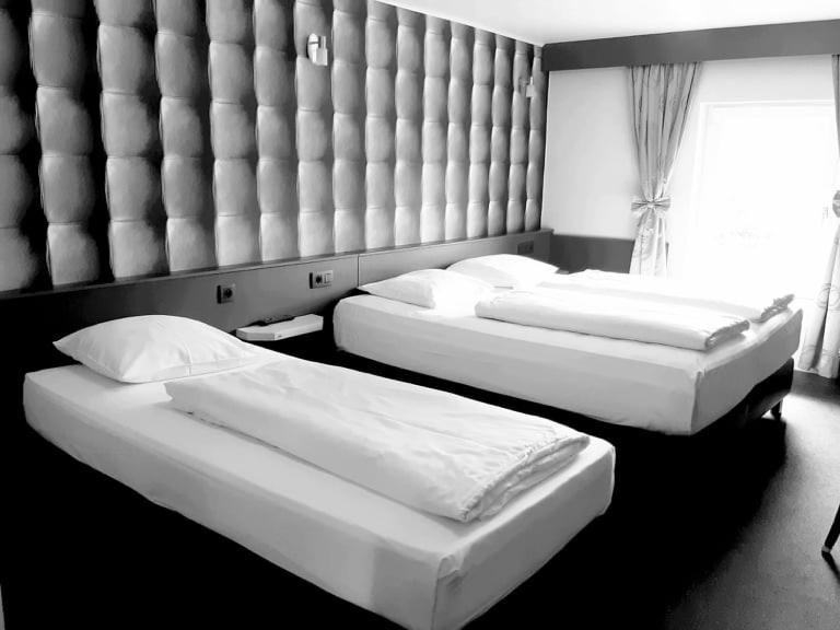 Postel nebo postele na pokoji v ubytování RAVeL Hotel Cyrano
