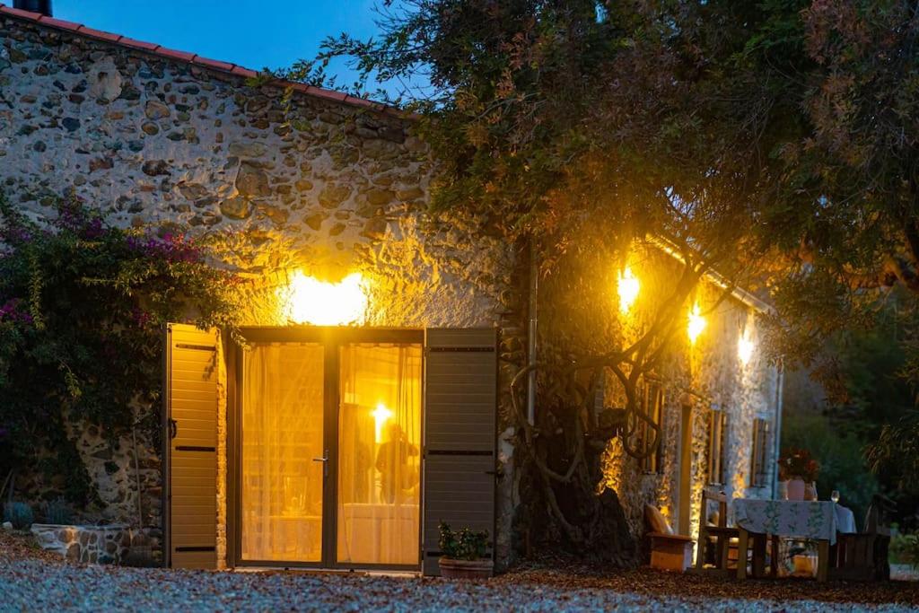 une maison avec des lumières sur le côté dans l'établissement Demeure de charme Suarella Domaine de Marquiliani, à Aghione