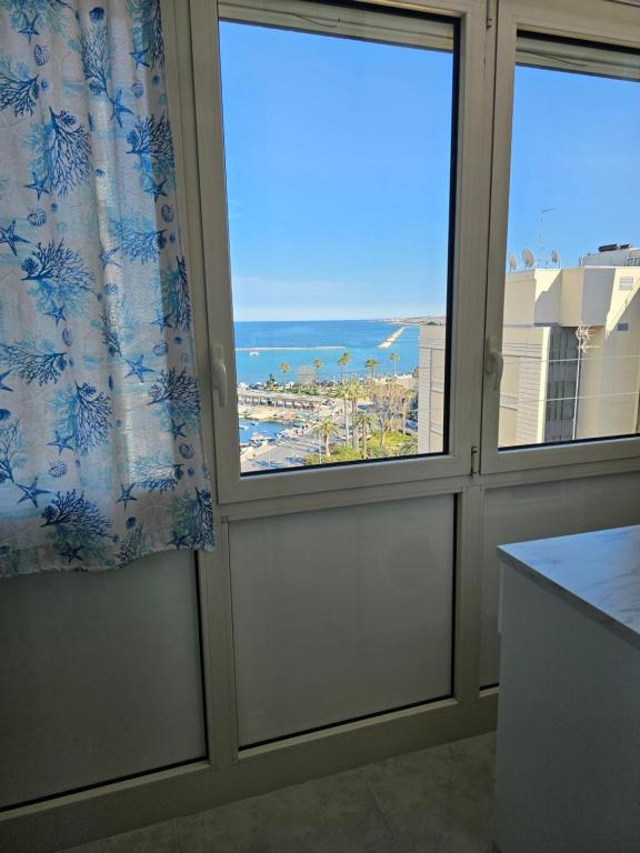 a room with two windows with a view of a beach at Mare Luna Apartment in Bari