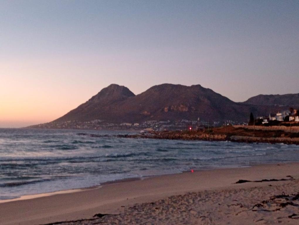 a view of a beach with mountains in the background at Relaxing Seaside Apartment in scenic Houtbay in Cape Town
