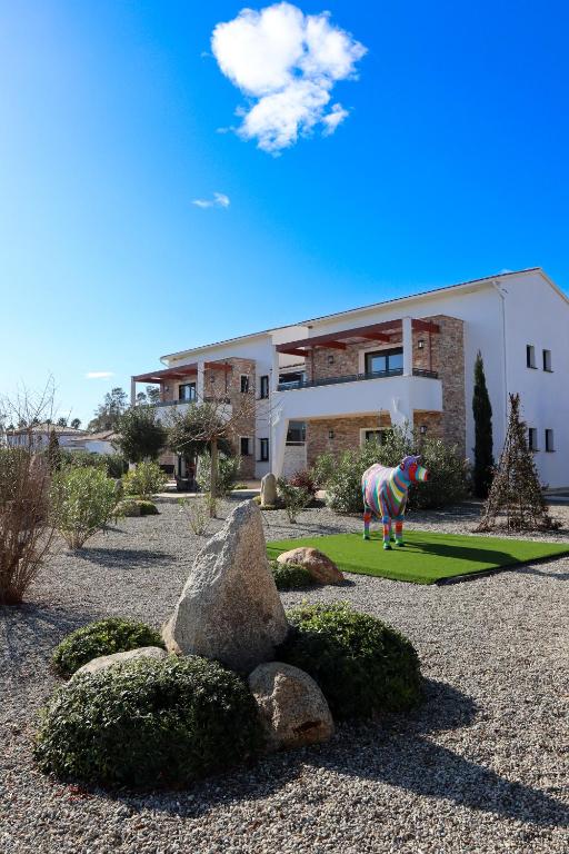 une statue d'une vache devant un bâtiment dans l'établissement Résidence La Dolce Vita, à Ghisonaccia