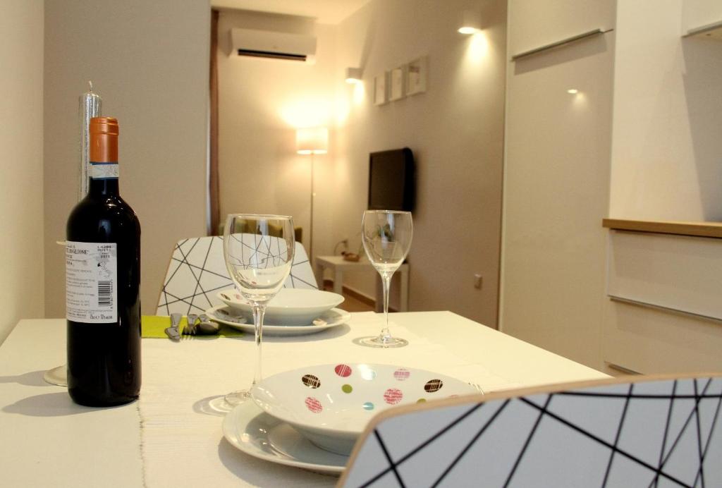 una bottiglia di vino seduta su un tavolo con due bicchieri di Apartment Remy a Pola (Pula)