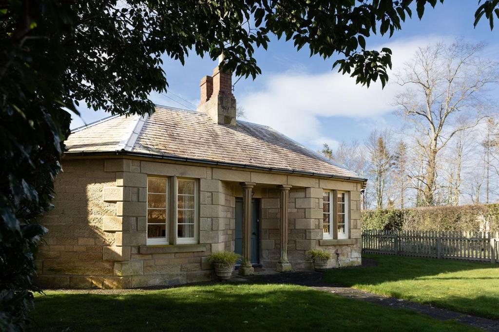 a small brick building with a chimney on top at Melkington Lodge in Cornhill-on-tweed