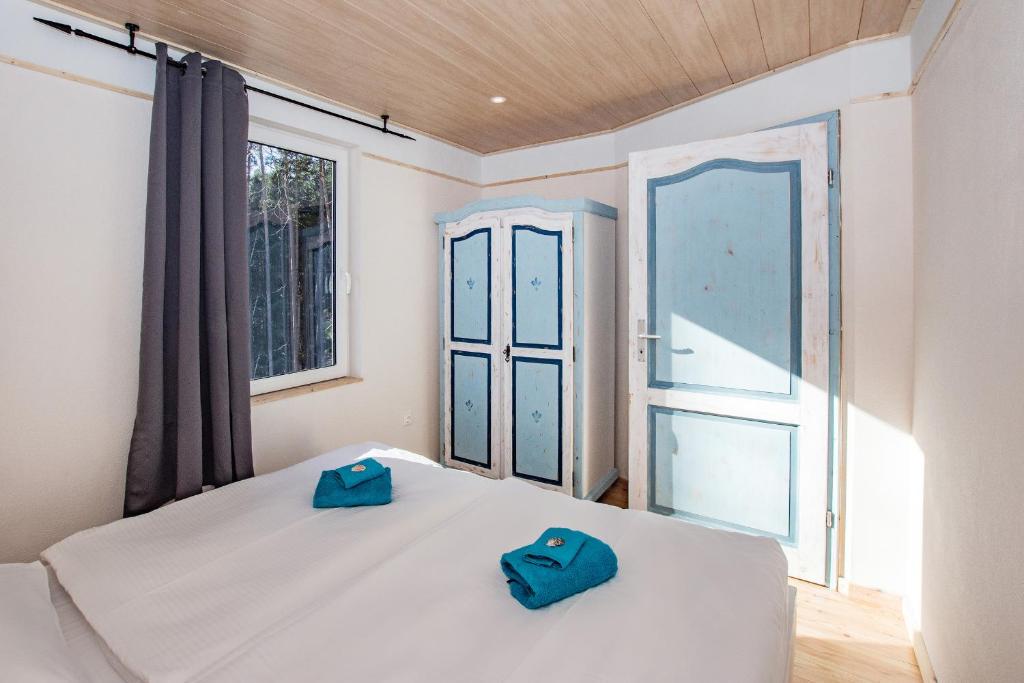 um quarto com uma cama com dois chinelos azuis em Krebssee em Ückeritz