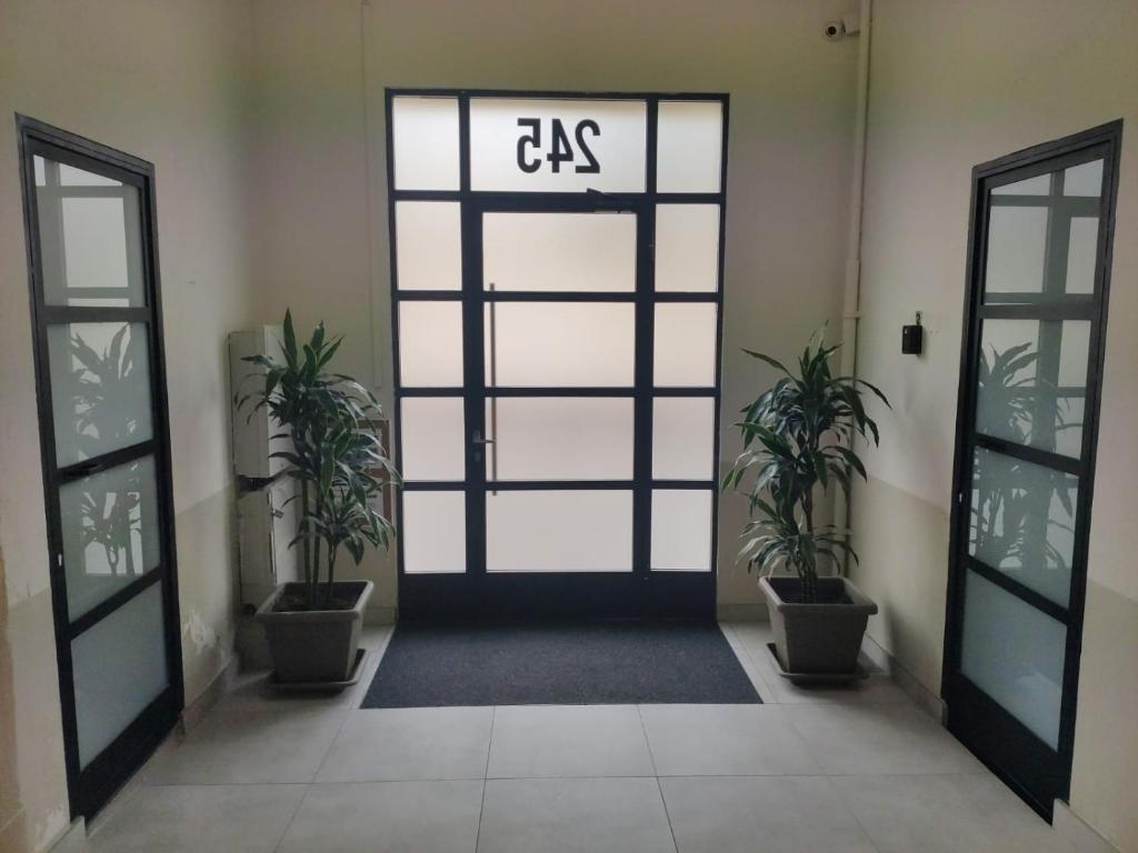 una puerta con una señal que lee cgs delante de dos plantas en Diagonal Apartments, en Barcelona