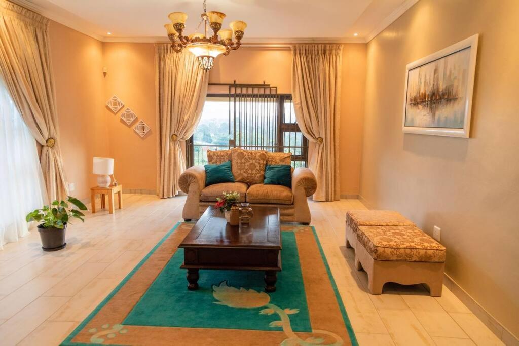 ein Wohnzimmer mit einem Sofa und einem Tisch in der Unterkunft Gorge View. in Mbabane