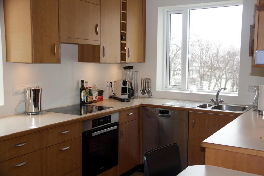 a kitchen with wooden cabinets and a window at Central by the Church *Family Villa in Akureyri