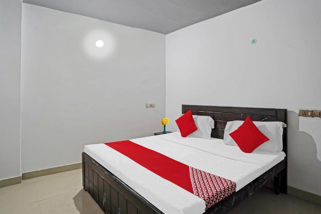 a bedroom with a bed with red and white pillows at OYO Sunrise Villa Near Select Citywalk Mall in New Delhi