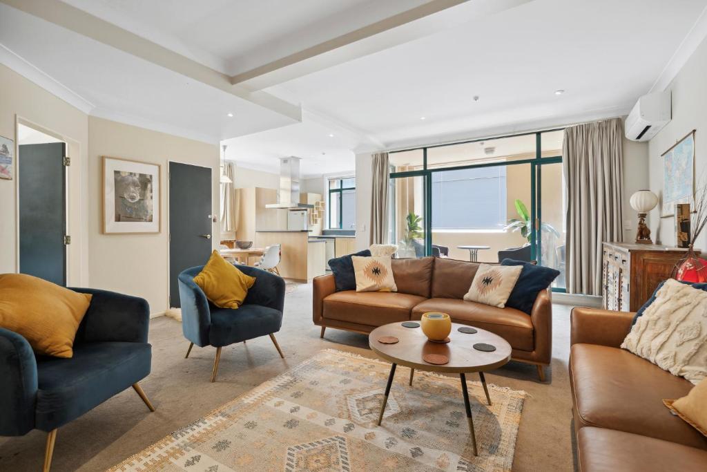 un soggiorno con 2 divani e un tavolo di The Urban Charmer - Wellington Holiday Apartment a Wellington
