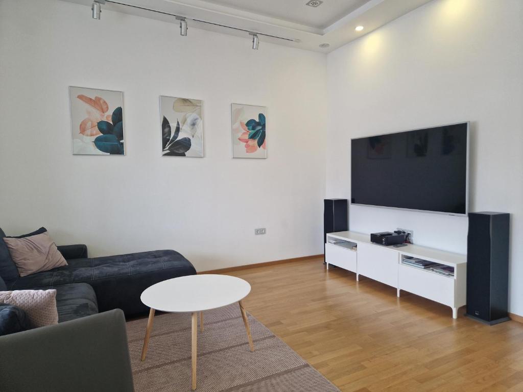 a living room with a couch and a tv and a table at 2 Ljubljana Modern Villa Apartment in Ljubljana