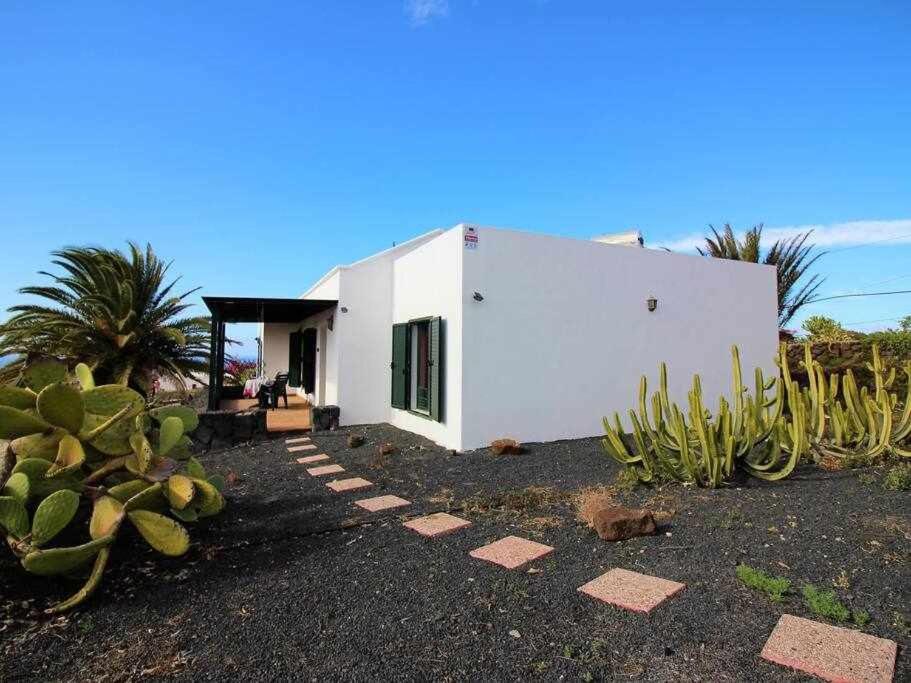 una casa bianca con cactus di fronte di Apartamento La Cancela a Las Breñas